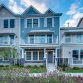 a front view of a house with a yard and potted plants