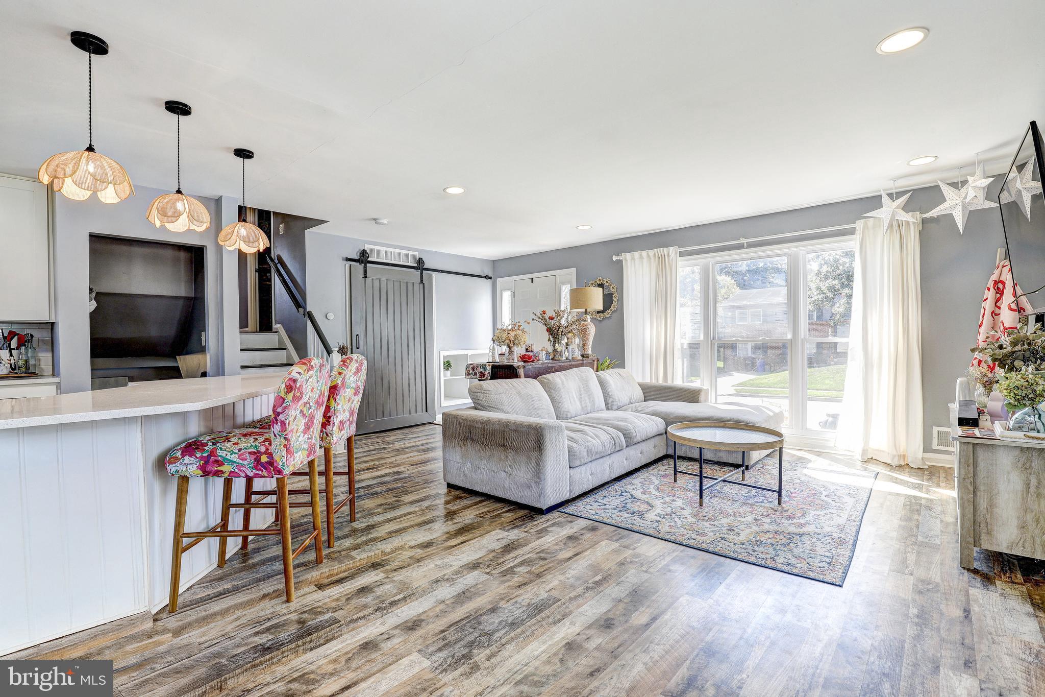 228 Quaker Ridge Road Lutherville-Timonium, MD 21093 - Photo 4 of 26 a living room with furniture a flat screen tv and a floor to ceiling window