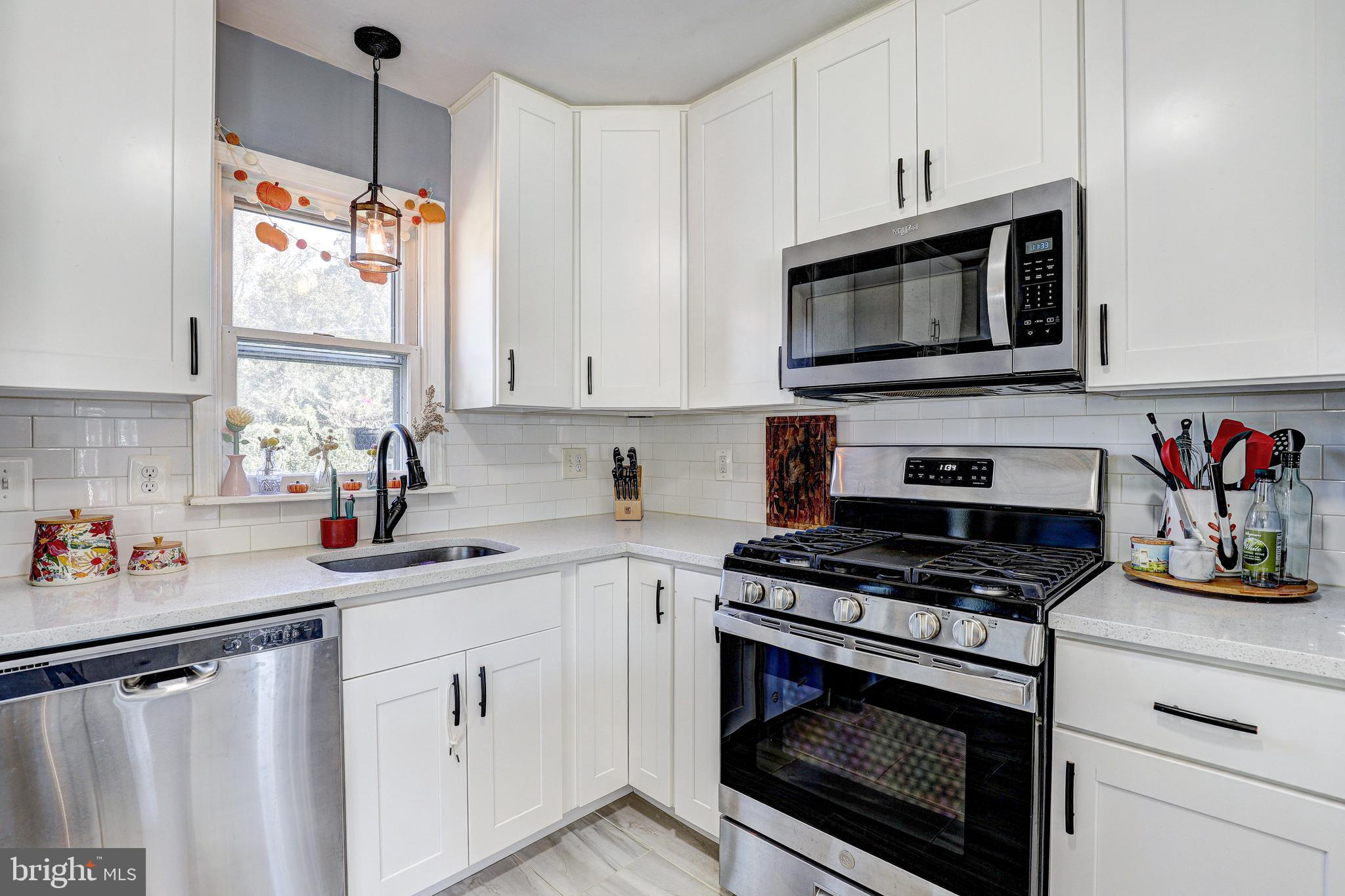 228 Quaker Ridge Road Lutherville-Timonium, MD 21093 - Photo 8 of 26 a kitchen with white cabinets stainless steel appliances and a sink