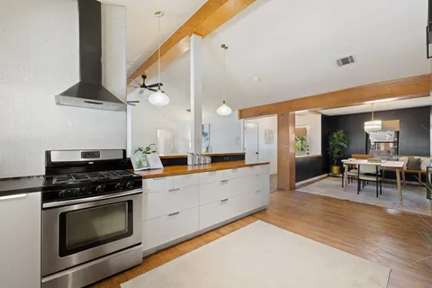 a kitchen with stainless steel appliances a stove a sink and cabinets