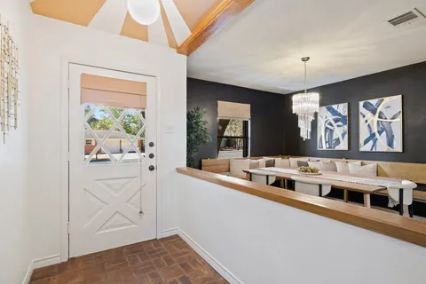 a white kitchen with stainless steel appliances granite countertop a stove and a large window