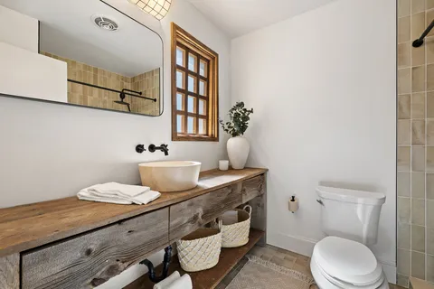 a bathroom with a granite countertop toilet sink and mirror