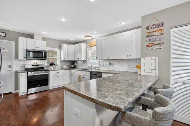 a kitchen with stainless steel appliances granite countertop a refrigerator sink and stove