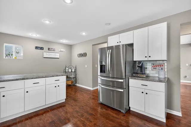 a kitchen with granite countertop white cabinets and stainless steel appliances