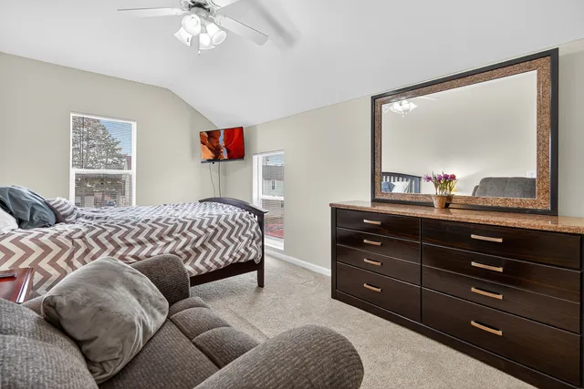 a bedroom with a bed and a mirror on dresser