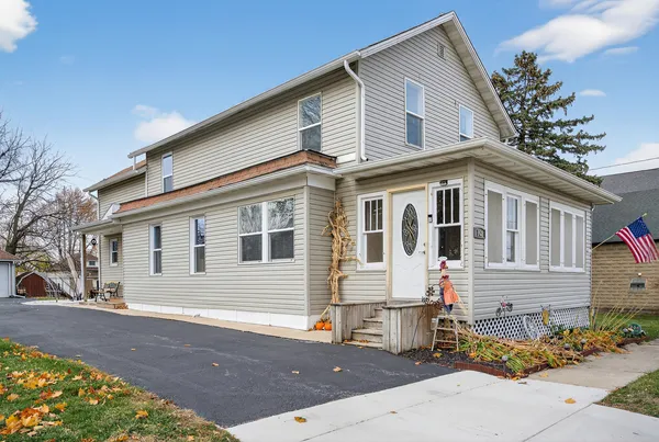 a front view of a house with a tree