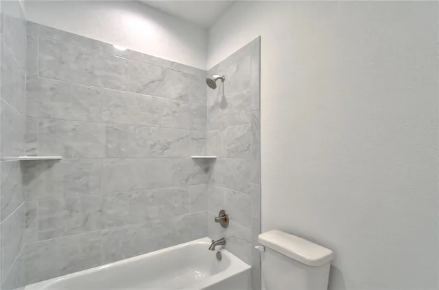 a white bath tub sitting next to a white toilet and sink