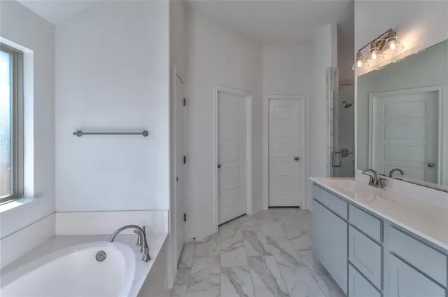 a bathroom with a tub sink and mirror