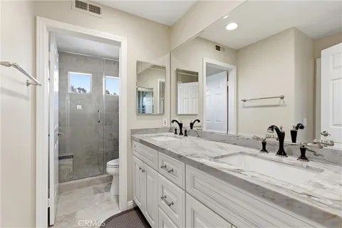 a bathroom with a granite countertop sink mirror and toilet