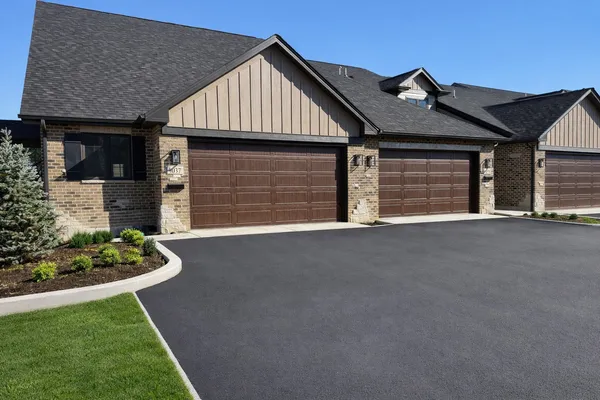 a front view of a house with a garden and yard