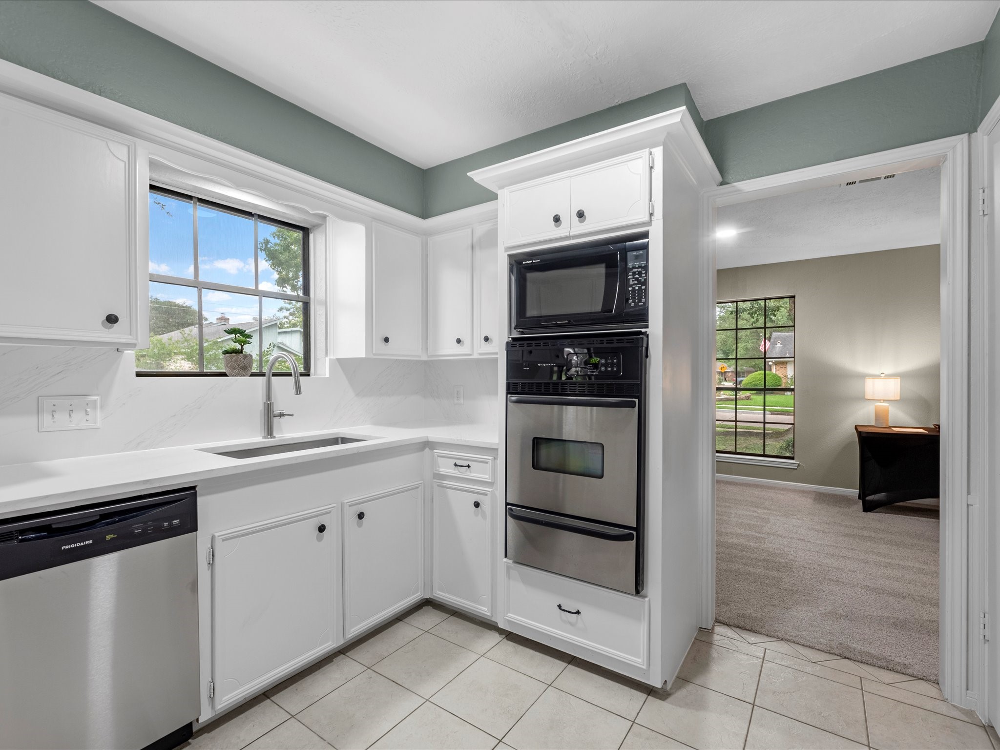 4002 Cujanes Street Pasadena, TX 77504 - Photo 11 of 26 a kitchen with stainless steel appliances a stove sink and microwave