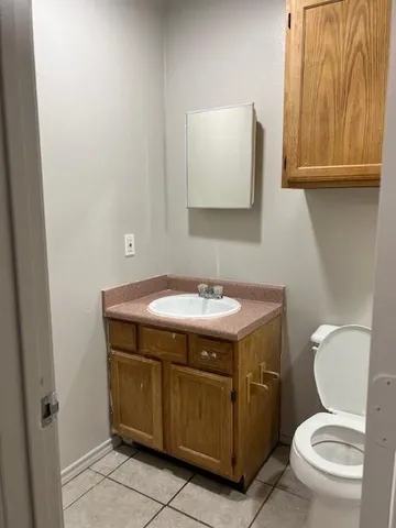 a bathroom with a granite countertop toilet and a sink