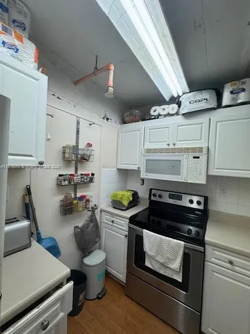 a kitchen with a stove and white cabinets