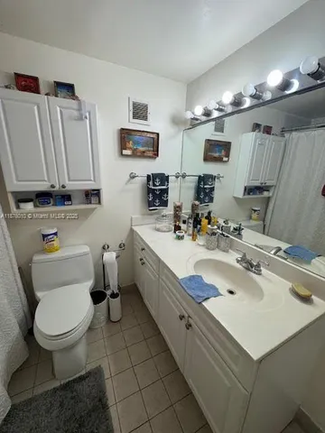 a bathroom with a sink mirror vanity and toilet