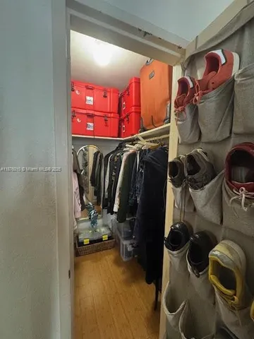 a view of walk in closet with clothes and shoes