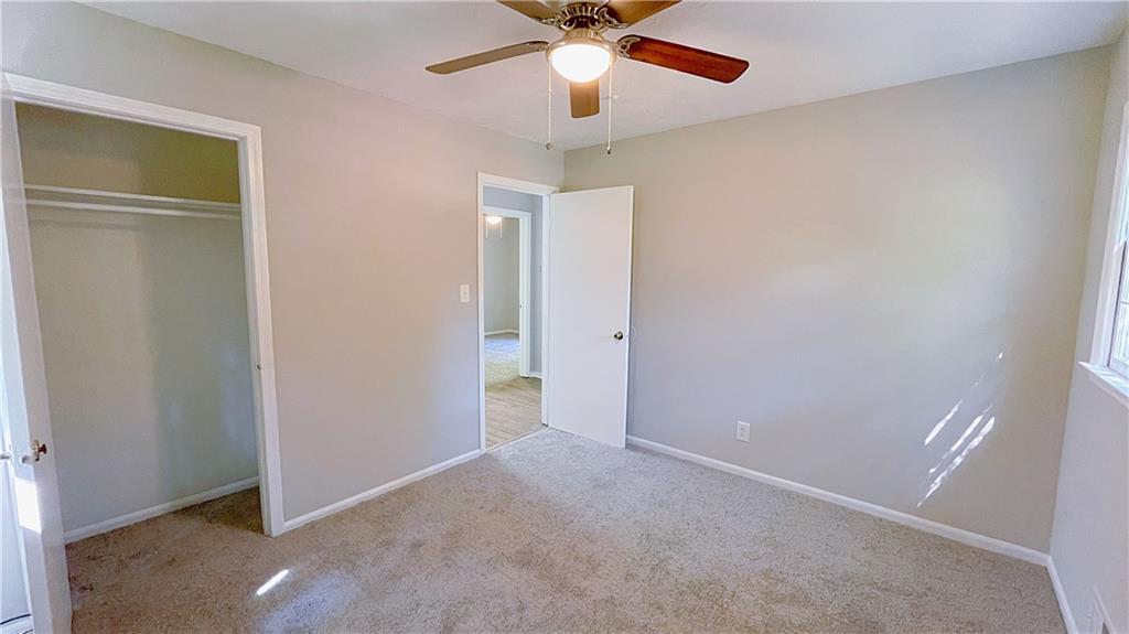 122 Barnesville Road Griffin, GA 30224 - Photo 12 of 19 an empty room with closet and a chandelier fan