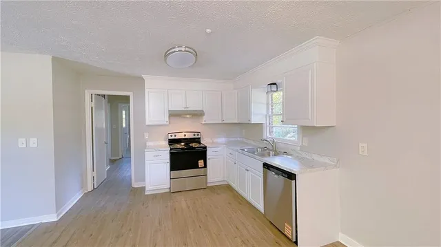 a kitchen with stainless steel appliances granite countertop a stove a sink and a refrigerator