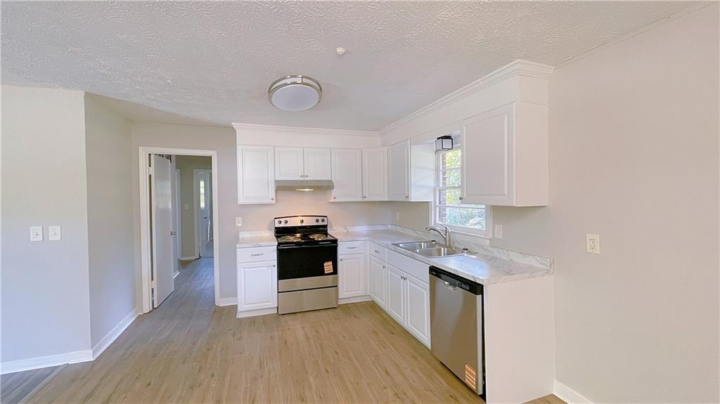 122 Barnesville Road Griffin, GA 30224 - Photo 5 of 19 a kitchen with stainless steel appliances granite countertop a stove a sink and a refrigerator