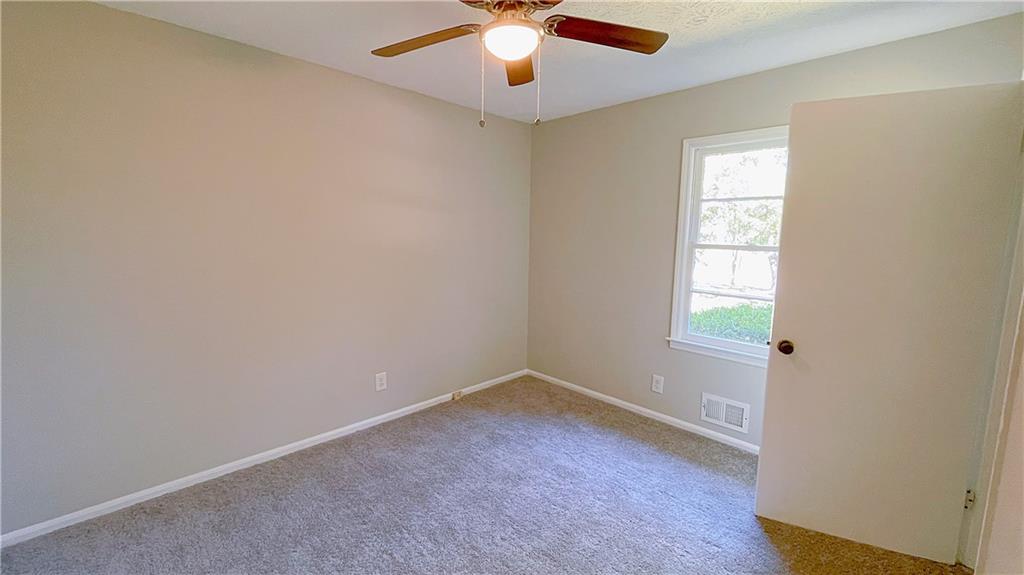 122 Barnesville Road Griffin, GA 30224 - Photo 7 of 19 an empty room with windows and chandelier fan