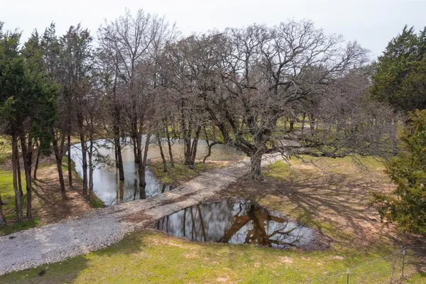 an aerial view of a house with swimming pool and mountains