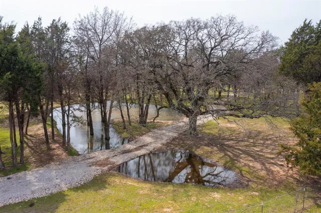 an aerial view of a house with swimming pool and mountains
