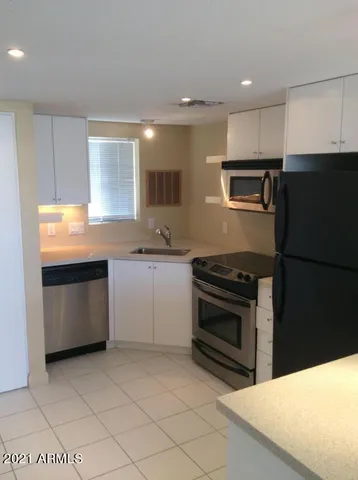 a kitchen with stainless steel appliances granite countertop a sink and a refrigerator