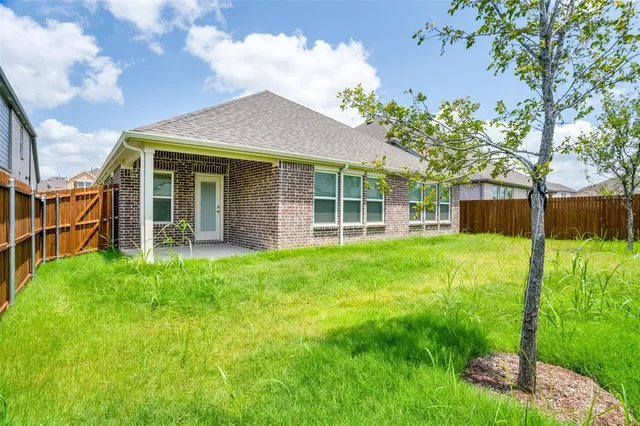 a view of a house with backyard and a tree