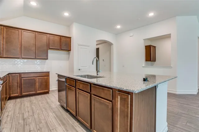 a kitchen with stainless steel appliances granite countertop a sink stove and cabinets