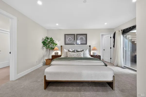 a bedroom with a bed and a lamp on dresser