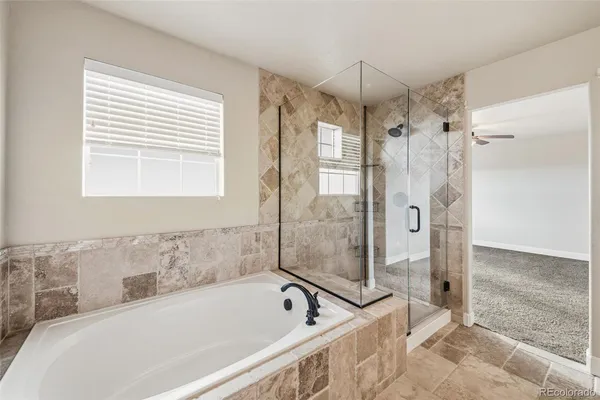 a white bath tub sitting next to a shower