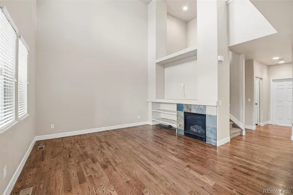 an empty room with wooden floor and fireplace