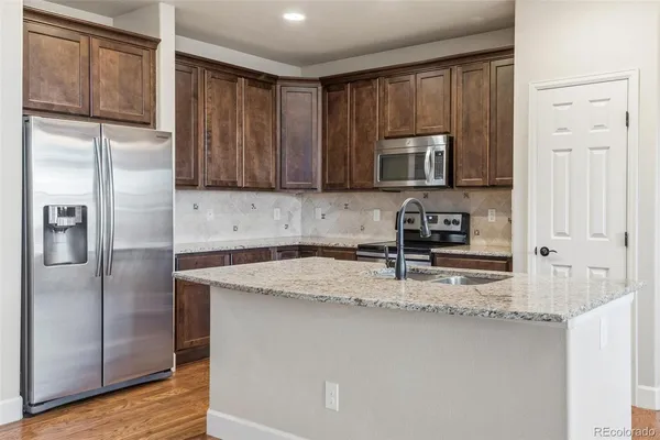 a kitchen with kitchen island a counter top space cabinets and stainless steel appliances