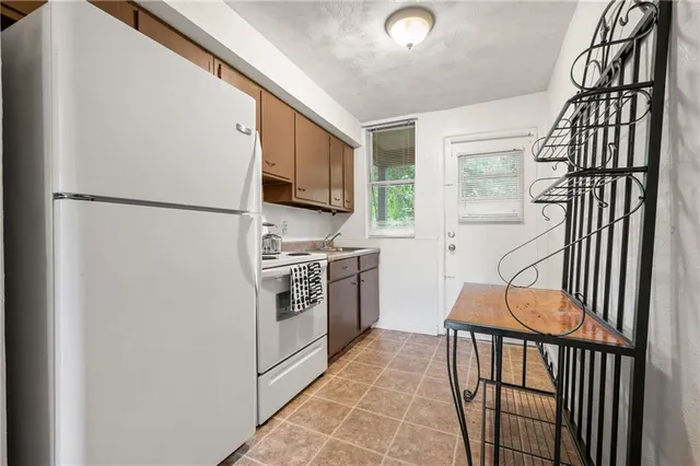 a kitchen with a refrigerator a stove and a window