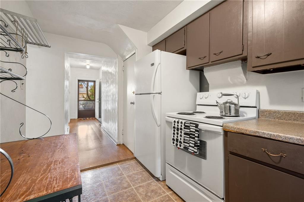 823 Lilac Street, Unit 1 Greenfield, PA 15217 - Photo 14 of 20 a kitchen with stainless steel appliances granite countertop a sink dishwasher a refrigerator and cabinets with wooden floor