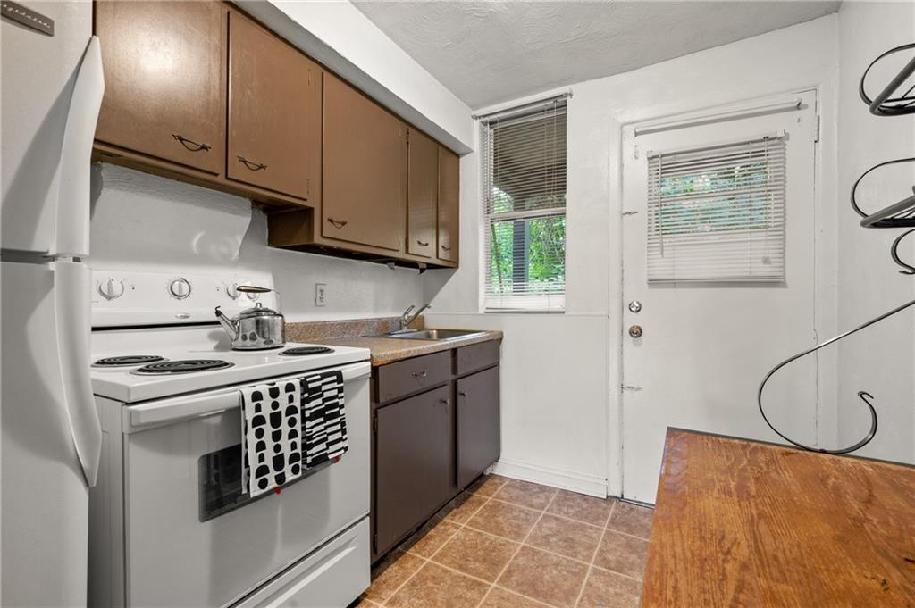823 Lilac Street, Unit 1 Greenfield, PA 15217 - Photo 16 of 20 a kitchen with stainless steel appliances granite countertop a sink stove and cabinets