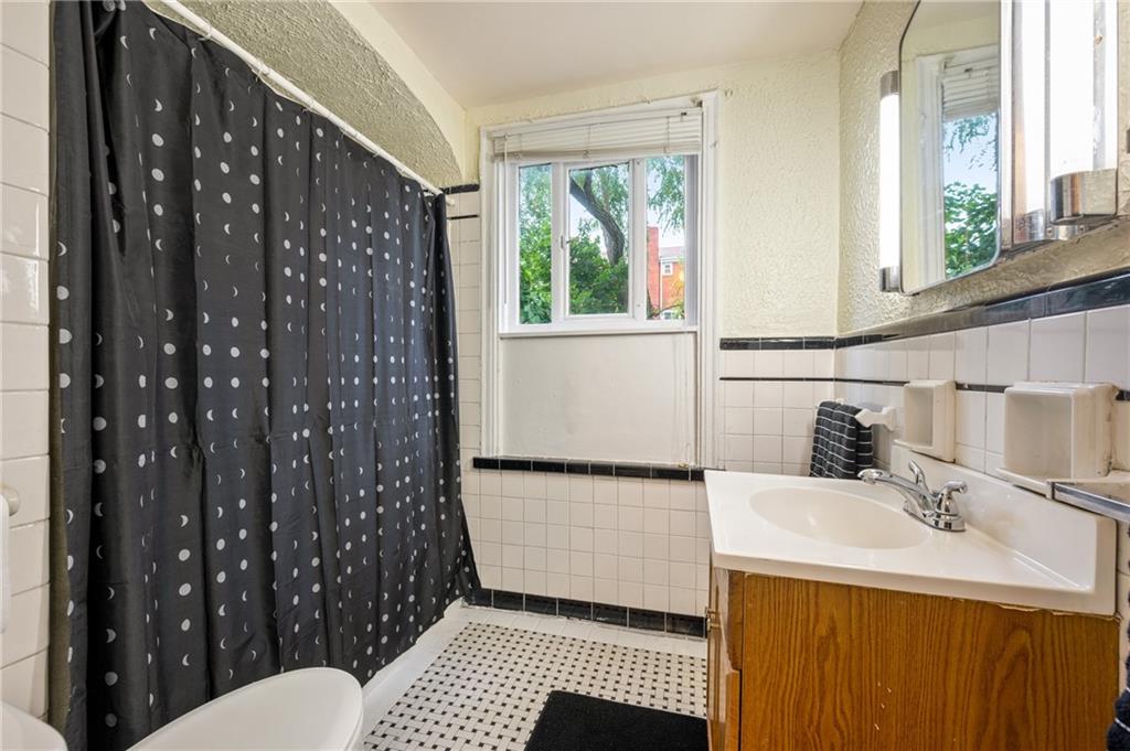 823 Lilac Street, Unit 1 Greenfield, PA 15217 - Photo 19 of 20 a bathroom with a sink toilet and shower
