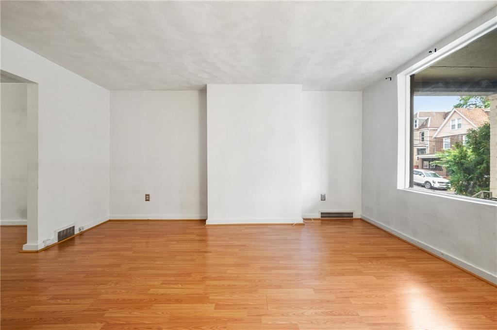 823 Lilac Street, Unit 1 Greenfield, PA 15217 - Photo 7 of 20 a view of an empty room with wooden floor and a window