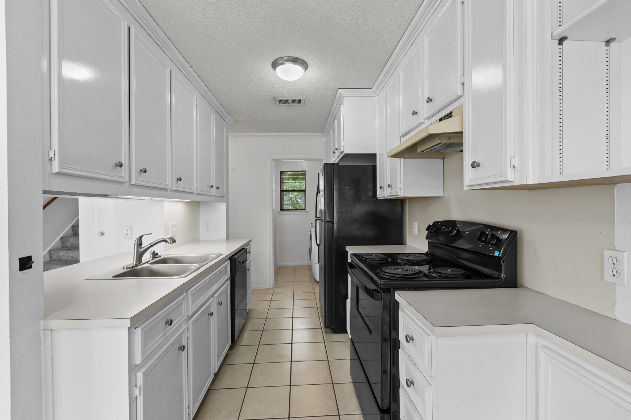 3845 Ranch Road 2222, Unit 26/M2 Austin, TX 78731 - Photo 5 of 21 Looking into the kitchen from the dining area to the laundry room. Tons of cabinets!