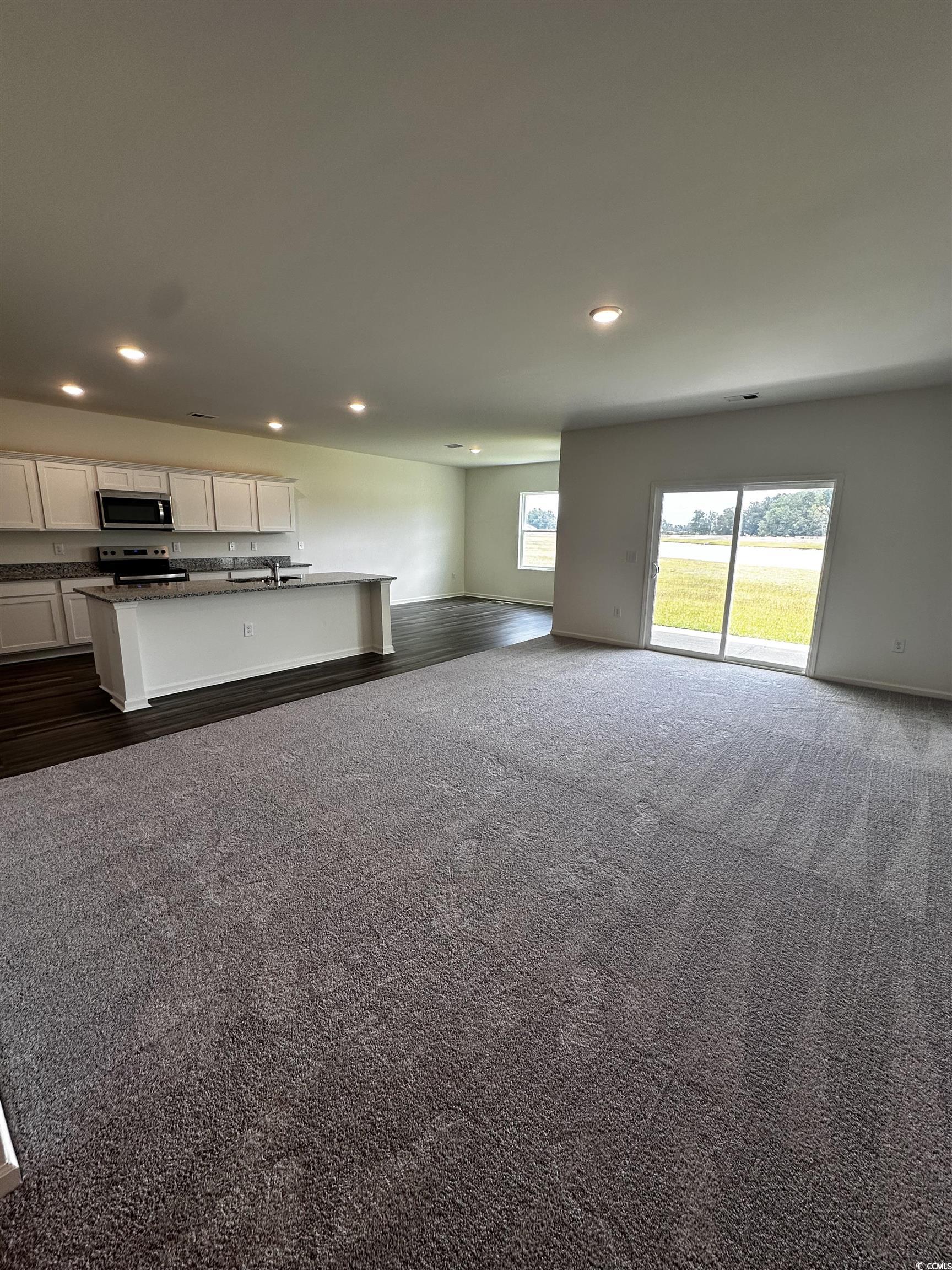 Unfurnished living room with sink and dark colored