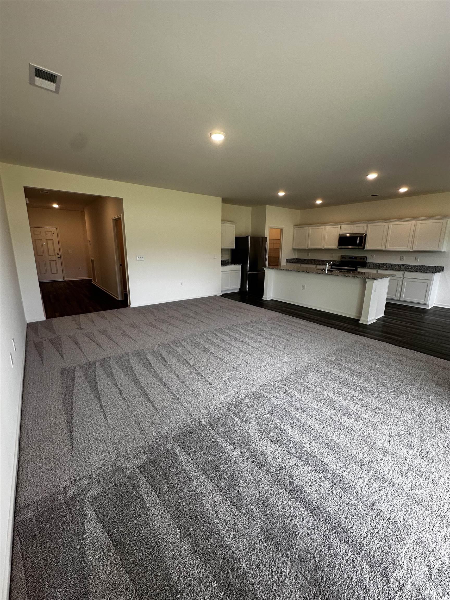 Unfurnished living room with dark carpet
