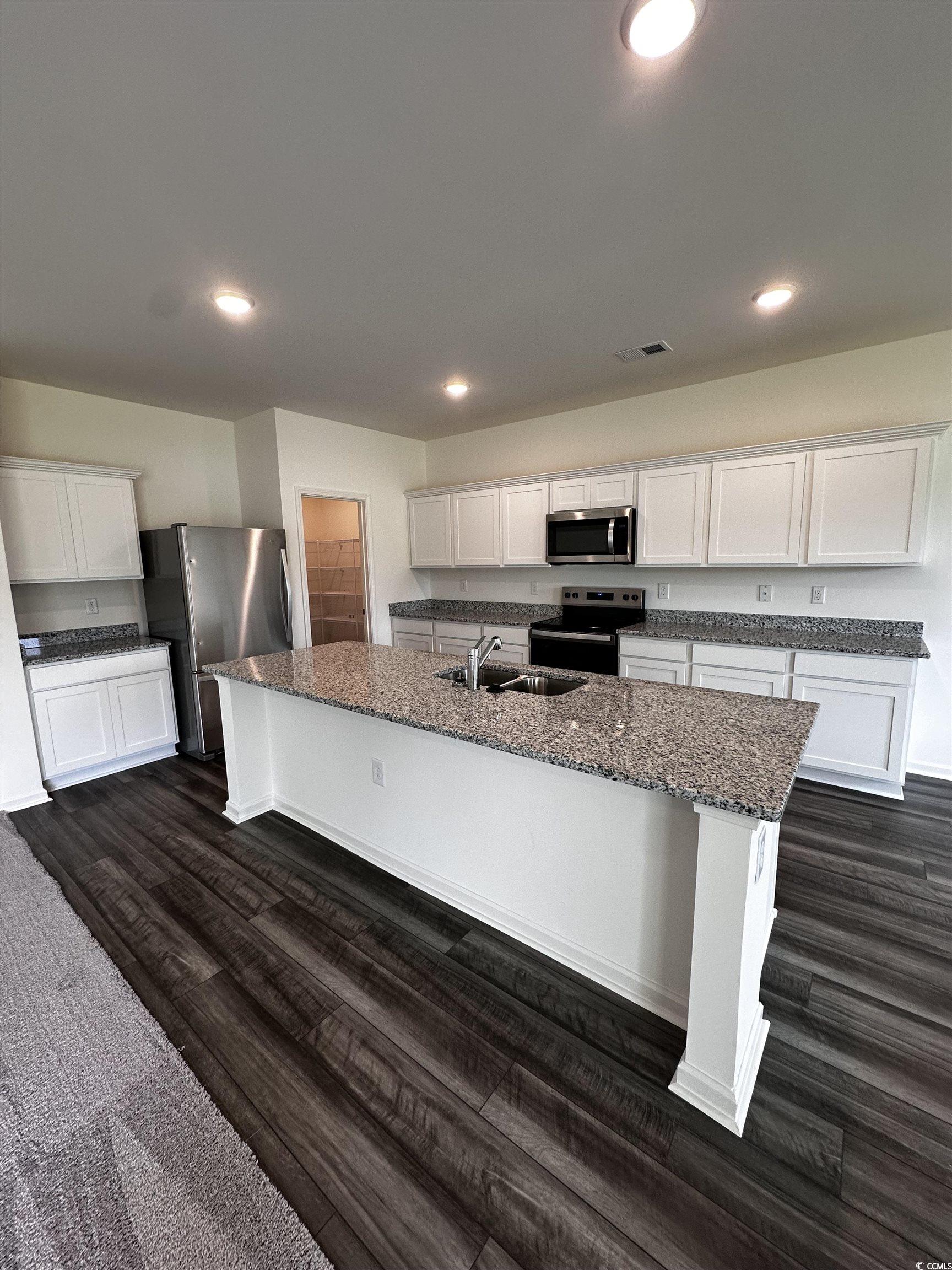 Kitchen featuring stainless steel appliances, dark