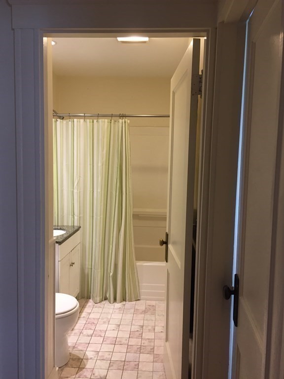 44 Webster Street, Unit 1 Arlington, MA 02474 - Photo 13 of 15 a bathroom with a granite countertop toilet a sink and a shower