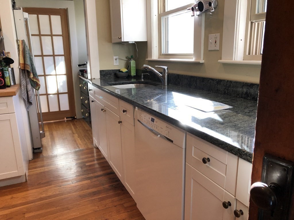 44 Webster Street, Unit 1 Arlington, MA 02474 - Photo 5 of 15 a kitchen with granite countertop a sink window and cabinets
