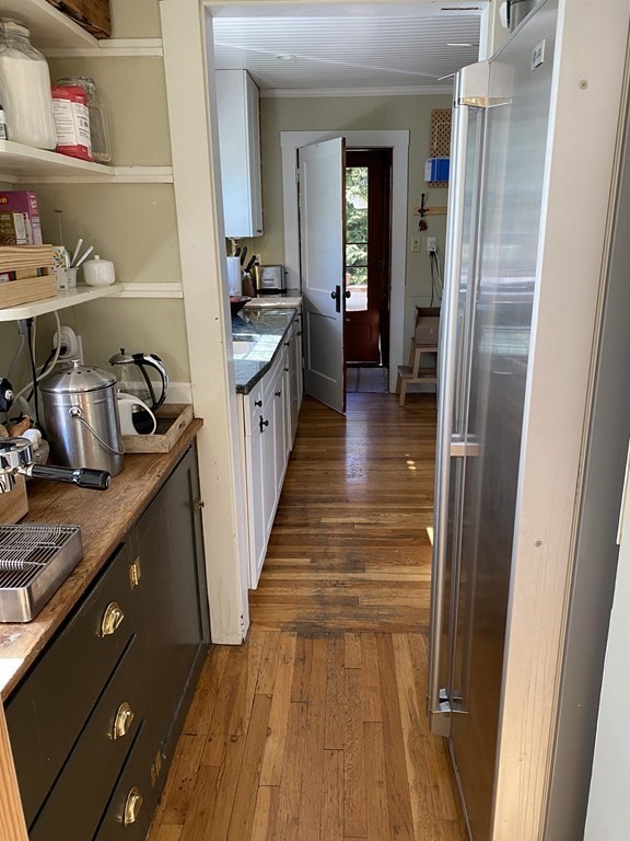 44 Webster Street, Unit 1 Arlington, MA 02474 - Photo 7 of 15 a hallway with white cabinets and wooden floor