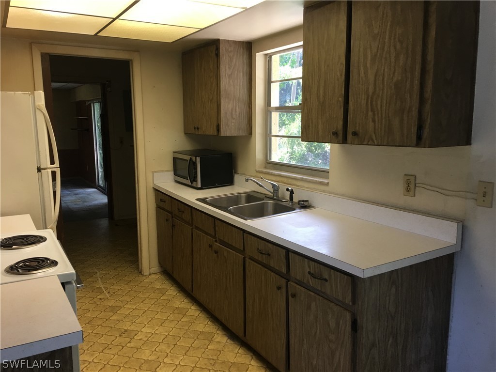 7229 Myrtle Road Fort Myers, FL 33967 - Photo 7 of 15 a kitchen that has a sink and a stove in it
