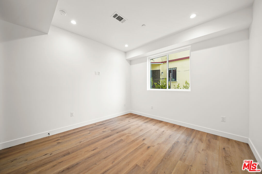 1520 Magnolia Avenue, Unit 1 Los Angeles, CA 90006 - Photo 15 of 21 an empty room with wooden floor and windows