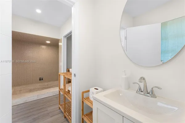 a bathroom with a sink a tub and a mirror