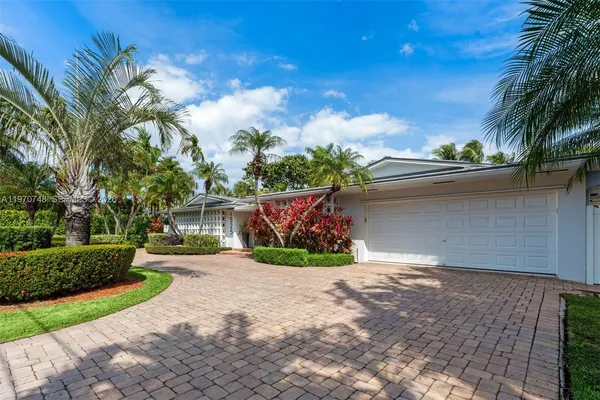 a front view of a house with a yard and potted plants