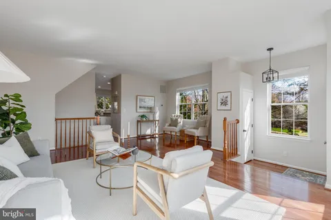 a living room with patio furniture and a chandelier