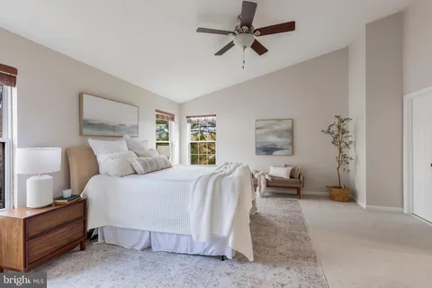 a spacious bedroom with a bed a couch and a chandelier